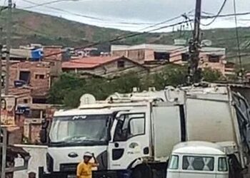 Caminhão de lixo enfrenta dificuldade para passar em rua estreita de Itabira durante coleta