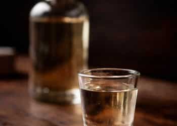 Copo de cachaça e garrafa após caso de suspeita de envenenamento em Santa Maria de Itabira