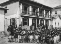 Antiga escola Coronel José Batista em Itabira com grande grupo de alunos reunidos em frente ao prédio histórico no início do século XX