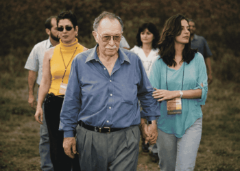 Luiz Menezes, ex-prefeito de Itabira, caminhando acompanhado durante visita em área rural do município