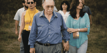 Luiz Menezes, ex-prefeito de Itabira, caminhando acompanhado durante visita em área rural do município