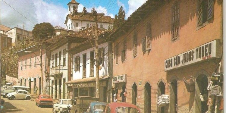 Foto antiga da Rua Tiradentes, em Itabira, com destaque para a loja de Nazareno Cabral, onde muitas famílias compravam tecidos para roupas de fim de ano e uniformes escolares.