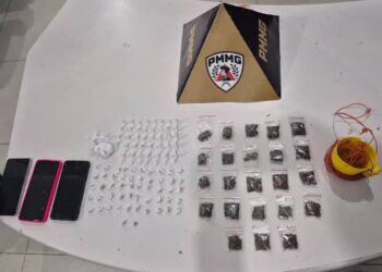 Materiais apreendidos pela Polícia Militar em operação contra o tráfico no bairro Madre Maria de Jesus, em Itabira, com porções de drogas, celulares e outros itens sobre uma mesa.