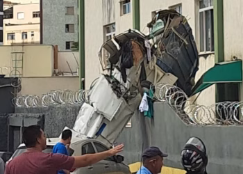 Avião de pequeno porte destruído após atingir prédio em Belo Horizonte, com destroços espalhados na área de estacionamento.