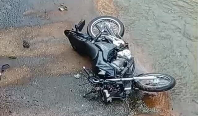 Motocicleta caída dentro de canal após acidente na avenida Li Guerra, no bairro Praia, em Itabira.